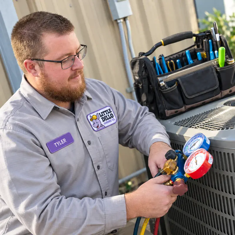Tyler of Little Dillo Service Co, a Kokomo HVAC technician, checking a refrigerant manifold gauge set