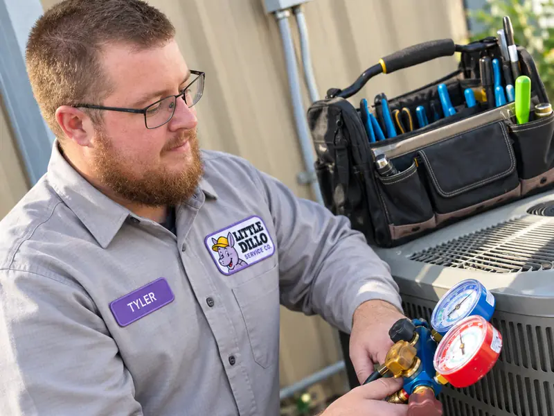 Tyler of Little Dillo Service Co, a Kokomo HVAC technician, checking a refrigerant manifold gauge set