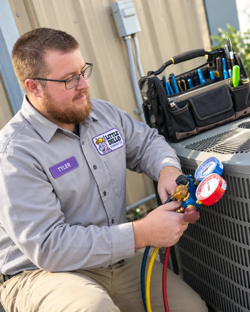Tyler of Little Dillo Service Co, a Kokomo HVAC technician, checking a refrigerant manifold gauge set
